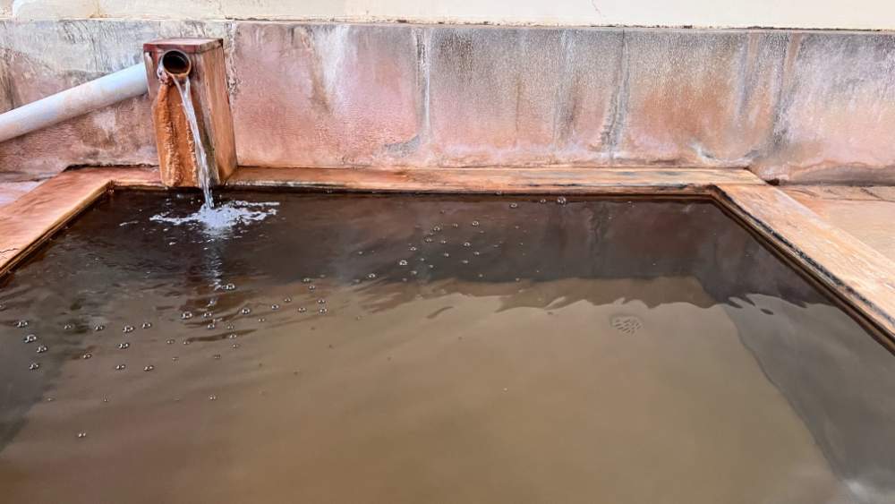 Large onsen bath filled with natural hotspring water.